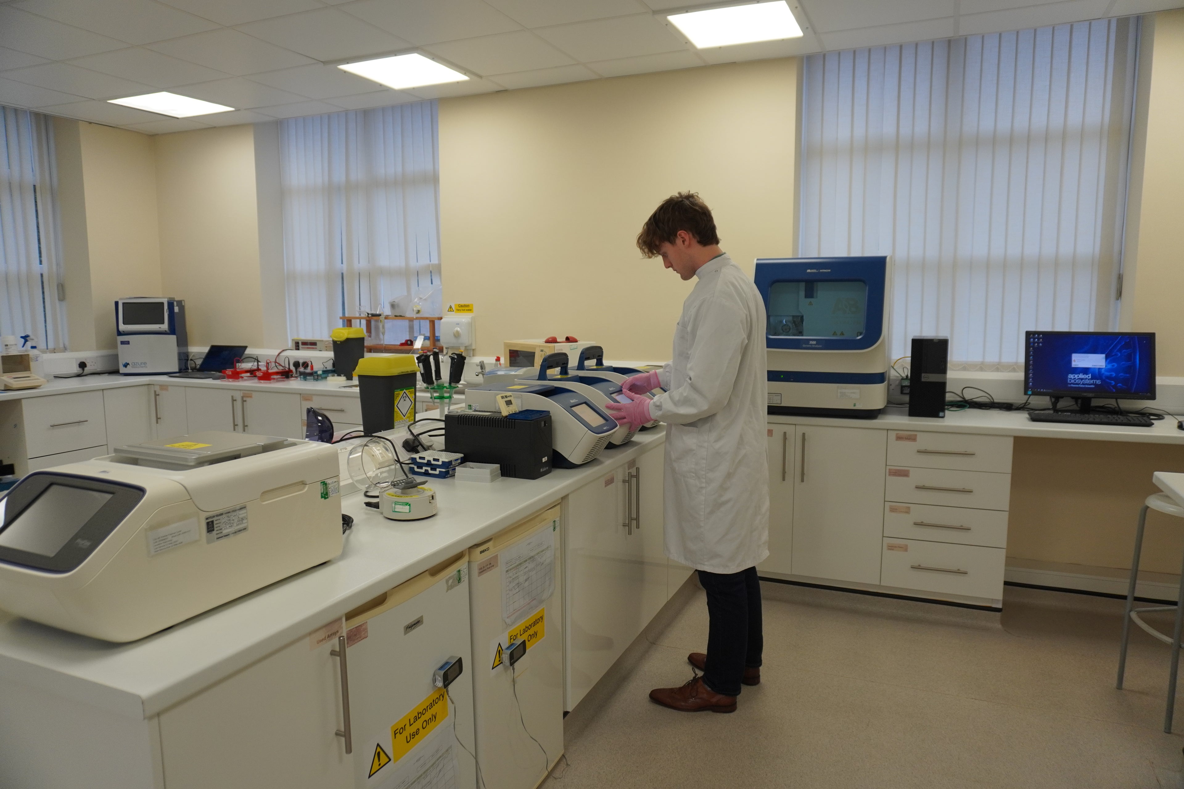Laboratory scientist processing samples at a clinical lab bench with diagnostic analysers — Endocrinology Plus extended blood test