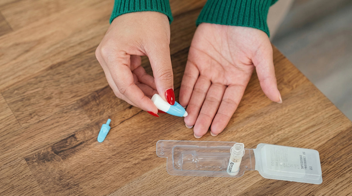 Person performing a finger-prick blood sample at home — At Home PSA Test kit for prostate health monitoring