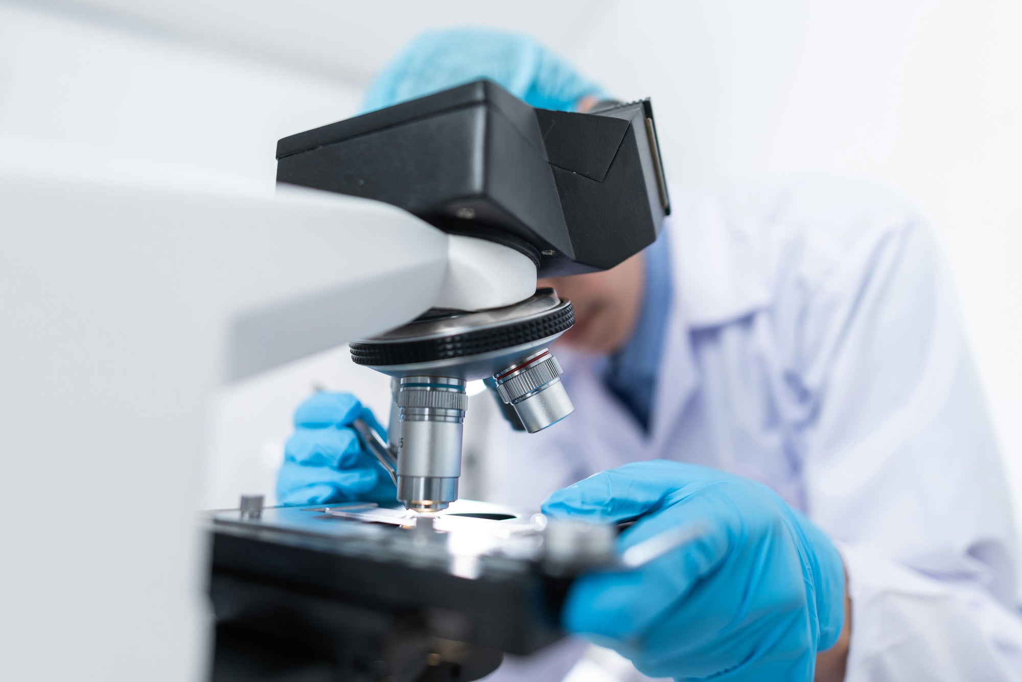 Laboratory scientist using a microscope in a clinical laboratory — Standard Screen comprehensive health blood test