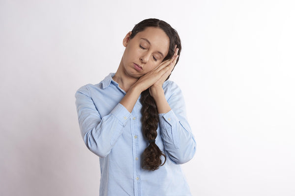 Fatigued woman with eyes closed and head resting on hands — Anaemia Profile blood test including Full Blood Count and Iron Status