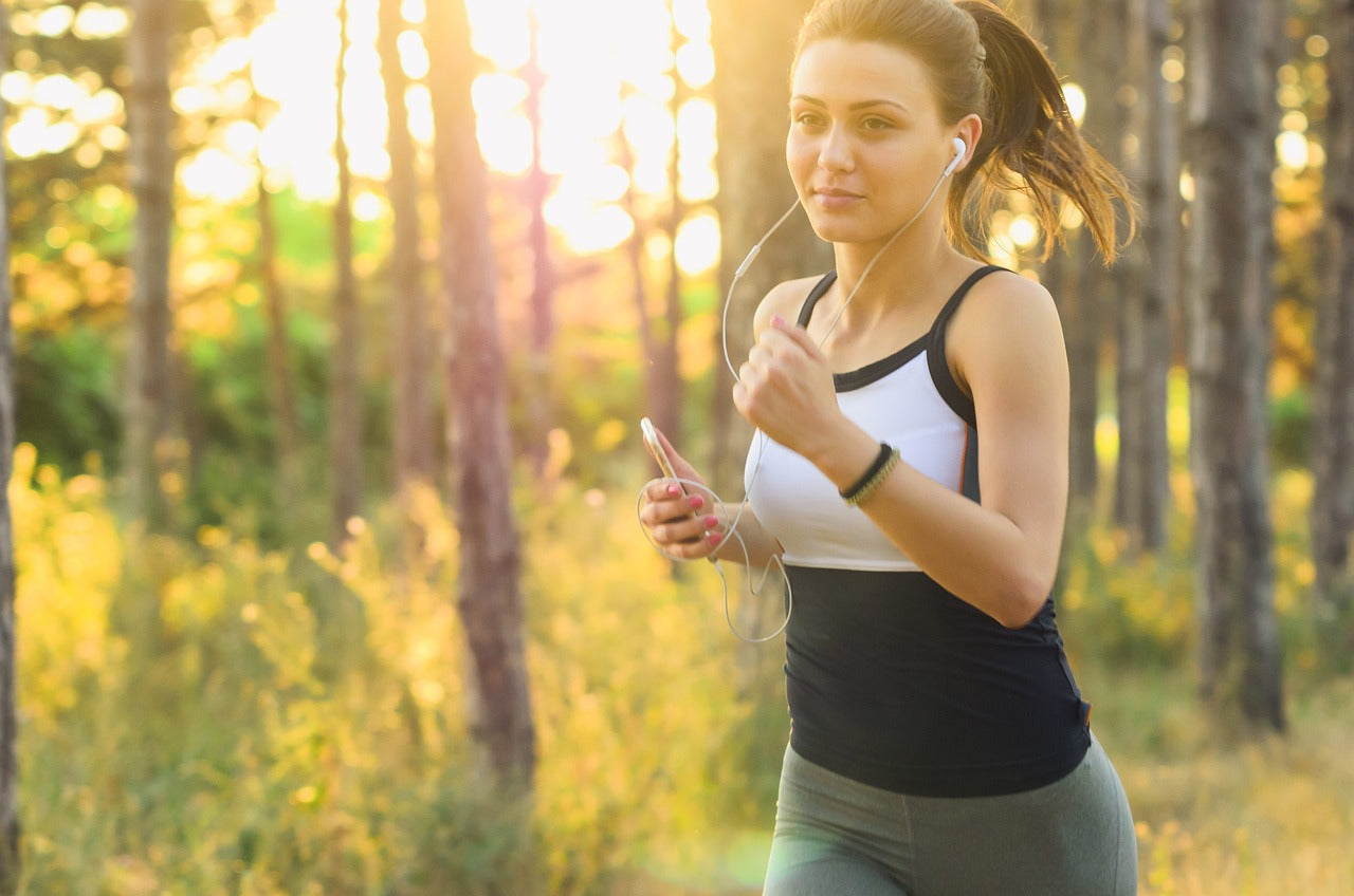 Woman jogging in a sunny forest with earphones — Advanced GP3 comprehensive blood test including hormonal, allergy and digestive health markers